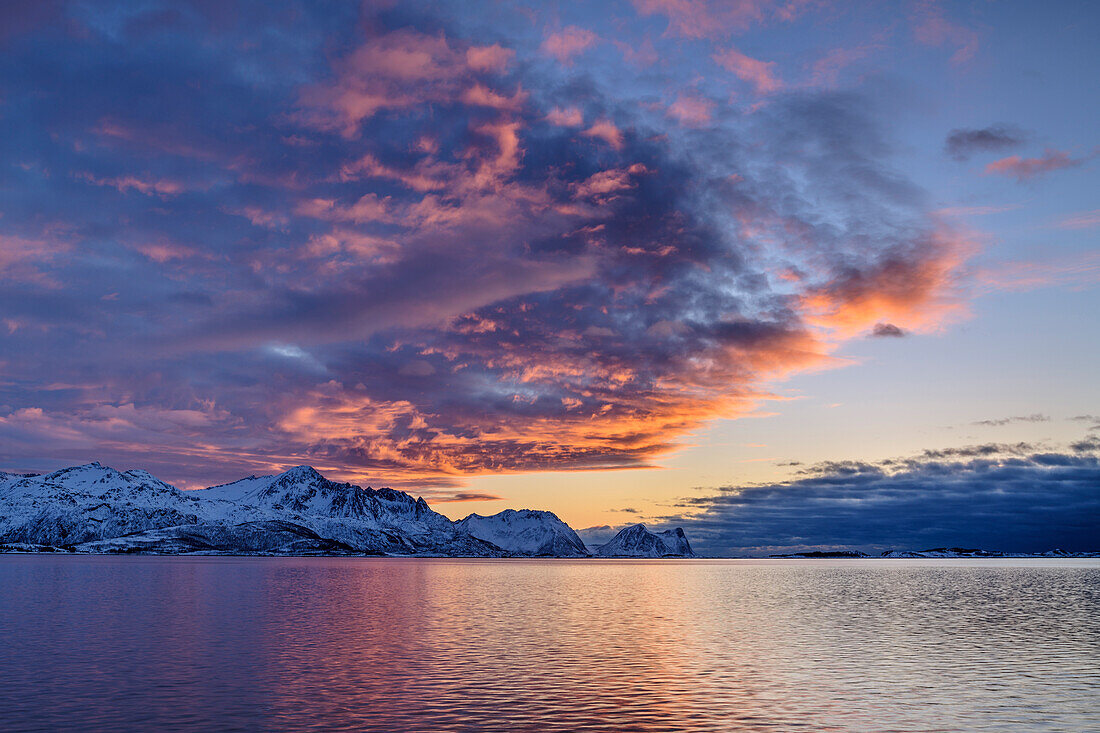 Glühende Wolken im Morgenlicht über dem Nordfjord, Skaland, Senja, Troms og Finnmark, Norwegen