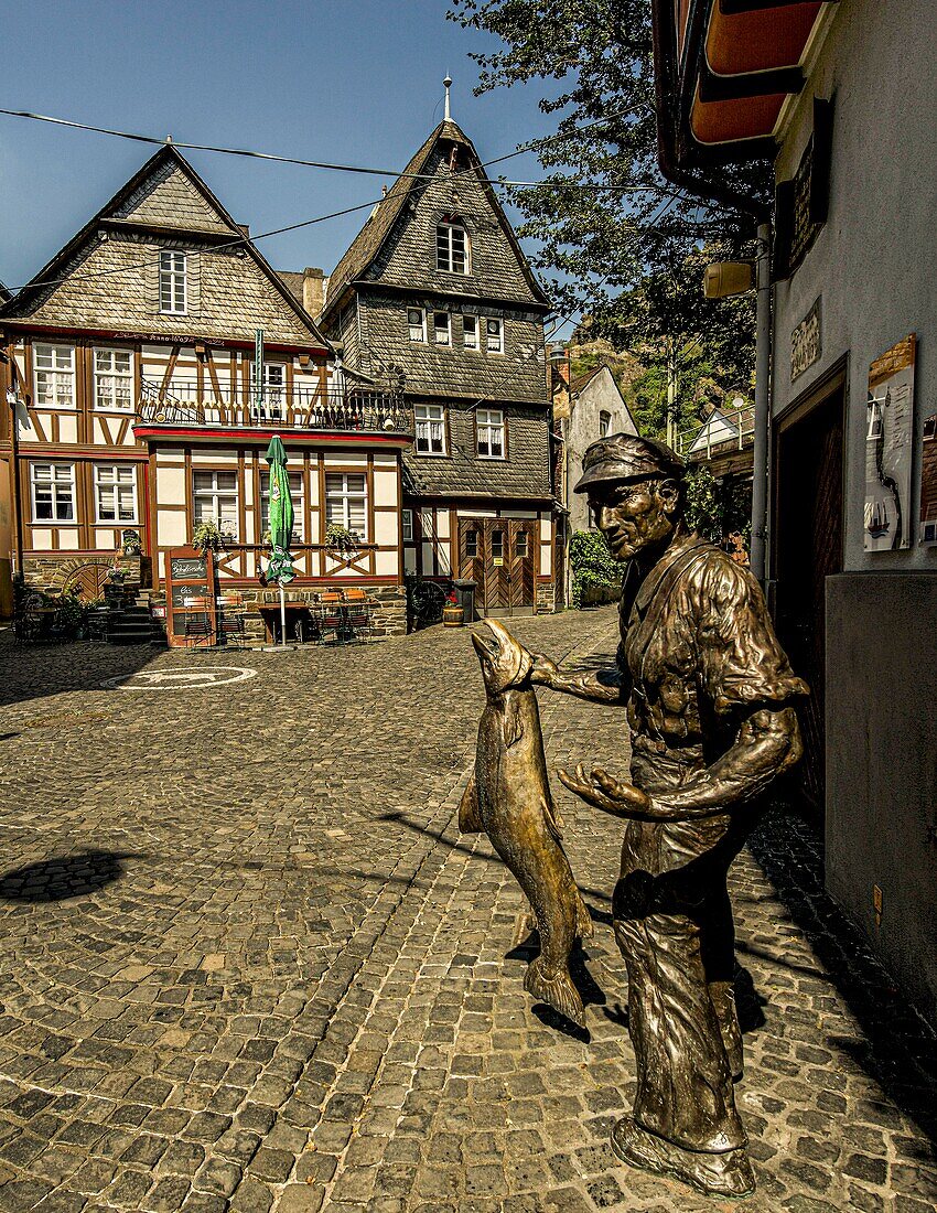 Statue eines Salmfischers und historische Bürgerhäuser in der Altstadt von St. Goarshausen, Oberes Mittelrheintal, Rheinland-Pfalz, Deutschland