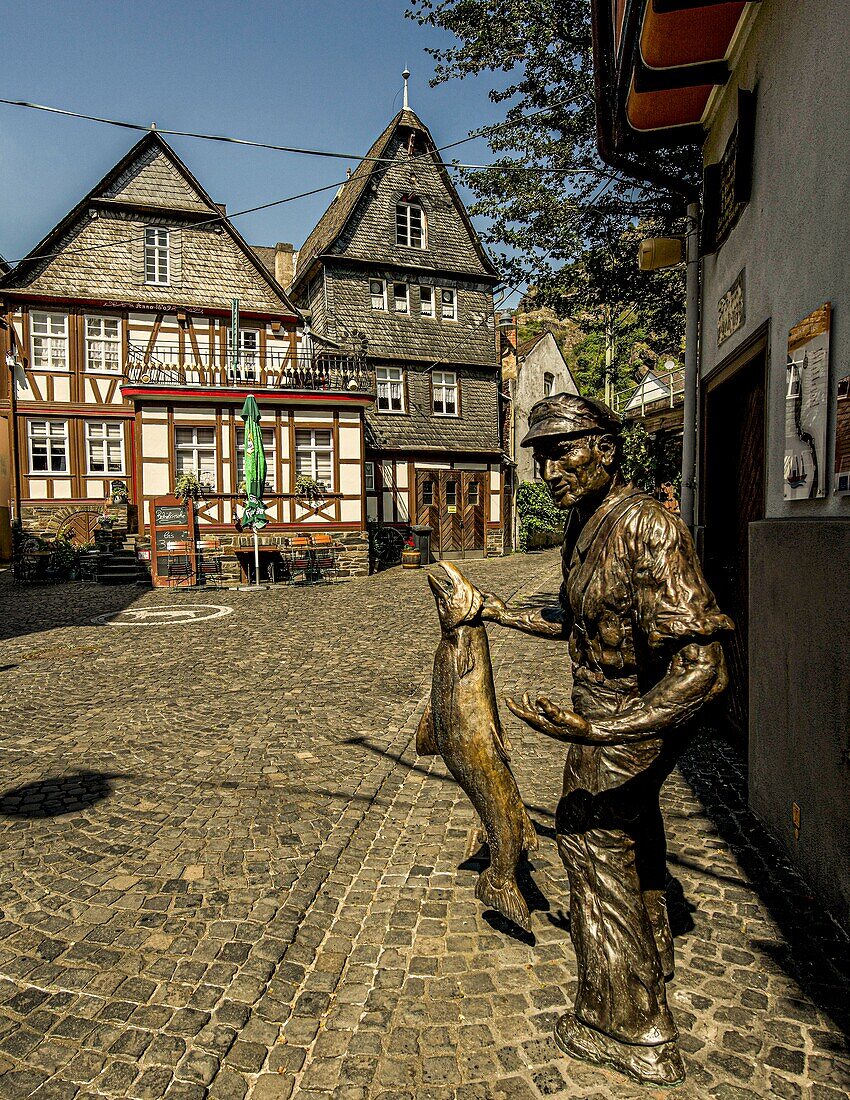 Statue of a salmon fisherman and historic town houses in the old town of St. Goarshausen, Upper Middle Rhine Valley, Rhineland-Palatinate, Germany