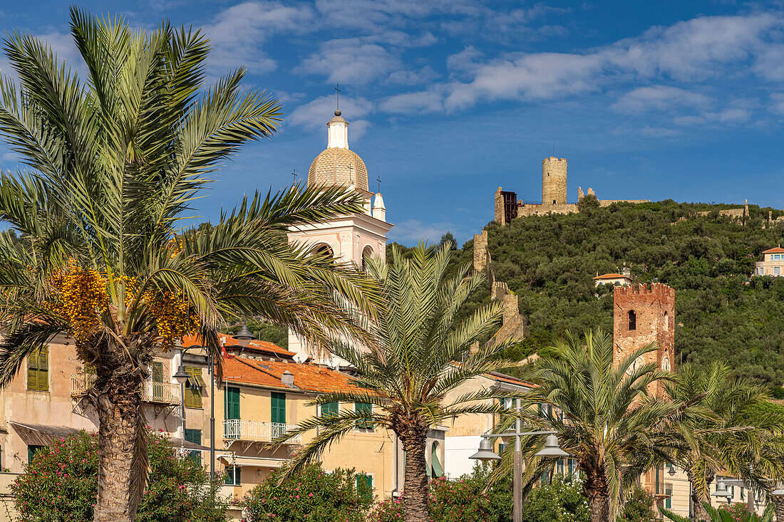 Palm trees of the waterfront cathedral and castle in Noli, Riviera di Ponente, Liguria, Italy, Europe