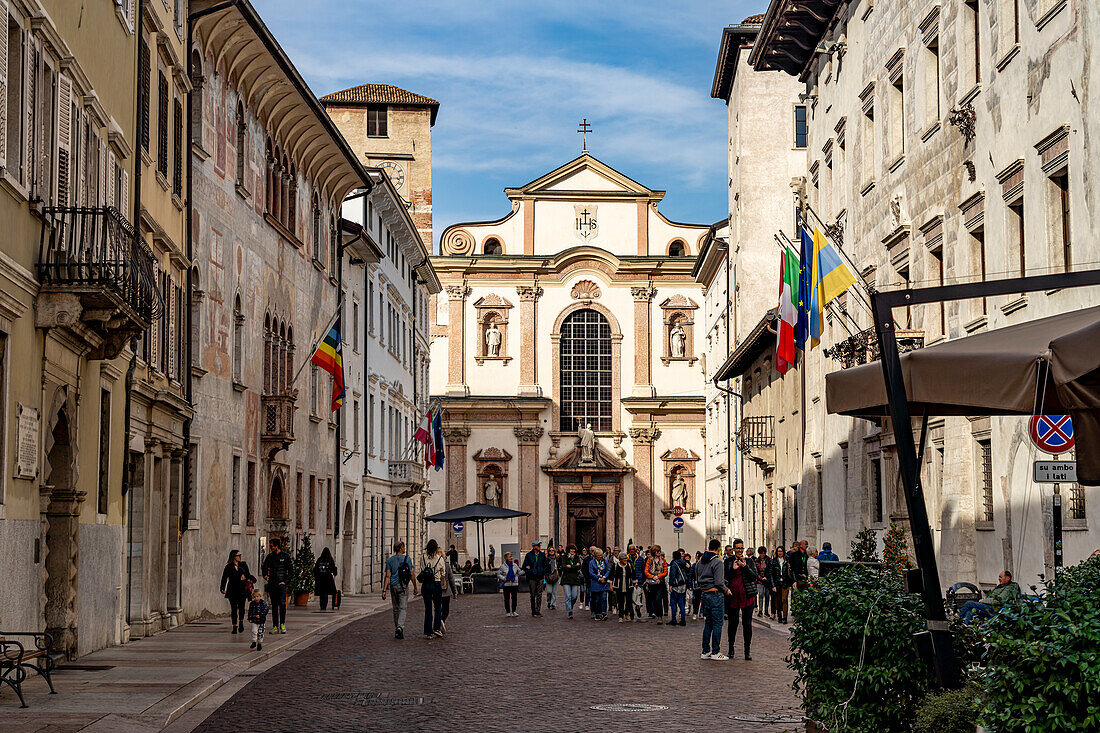 Via Rodolfo Belenzani in the old town and the church Chiesa di San Francesco Saverio in Trento, Trentino, Italy, Europe