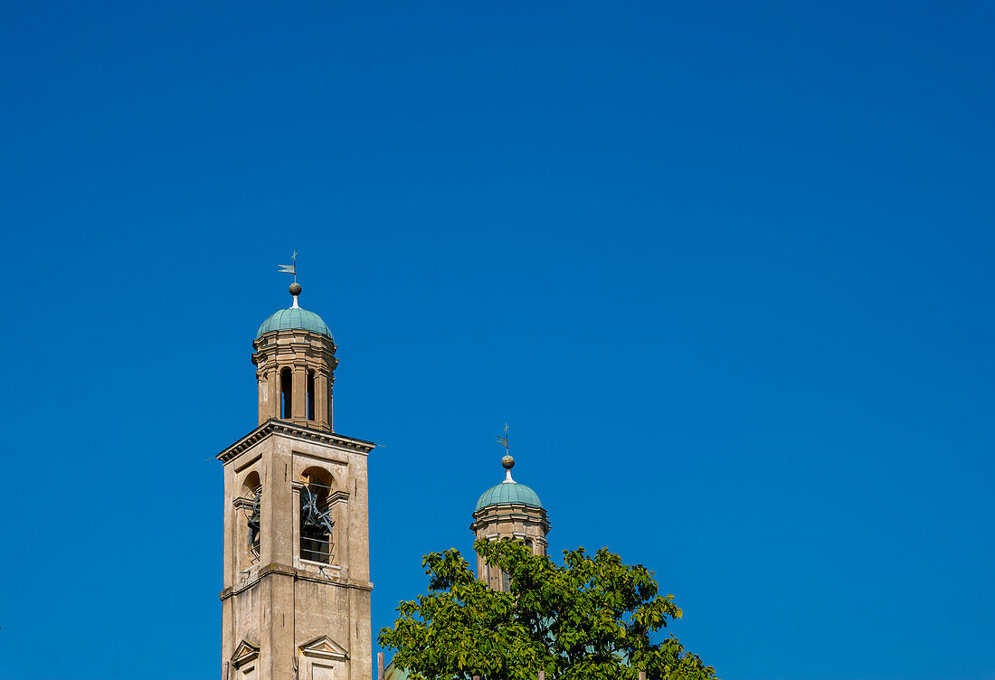 Kirche des Heiligen Kreuzes gegen blauen, klaren Himmel an einem sonnigen Tag in Riva San Vitale, Tessin, Schweiz