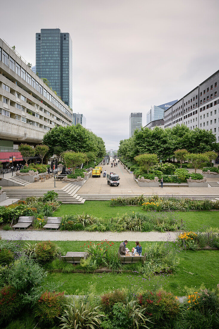 Man and woman eating in a green park in the middle of the modern high-rise district of La Défense in Paris, Île-de-France, France, Europe