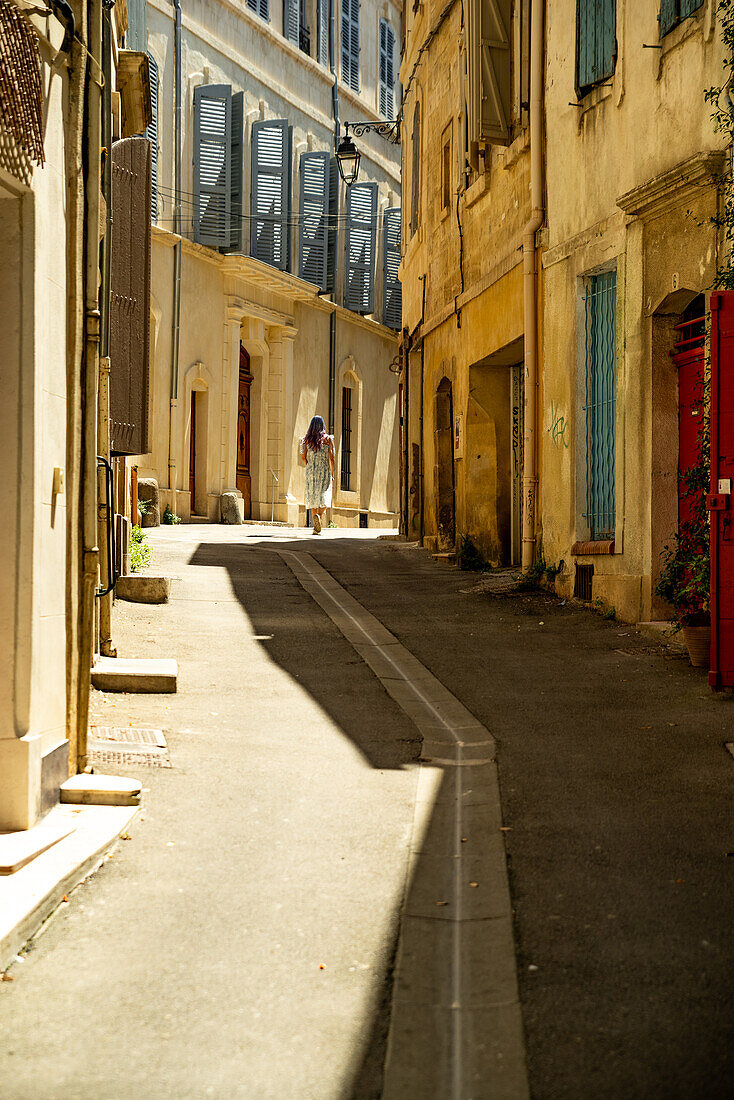 Frau geht an einem heißen Tag in Arles, Frankreich, die Straße entlang.