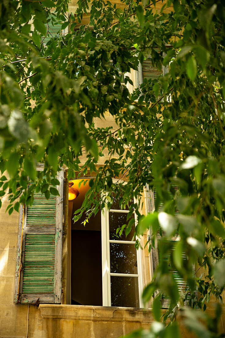 Fenster im Schatten an einem heißen Sommertag in der mittelalterlichen Stadt Arles, Frankreich.