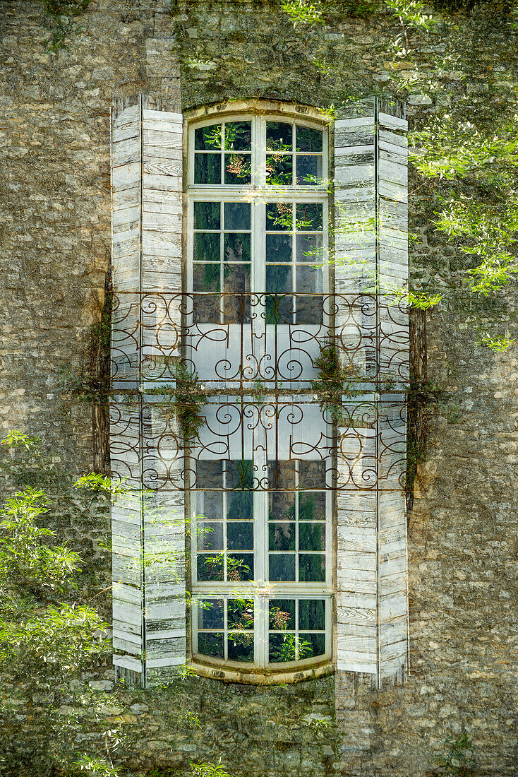 Doppelbelichtung eines Fensters mit verziertem Balkon in Arles, Frankreich.
