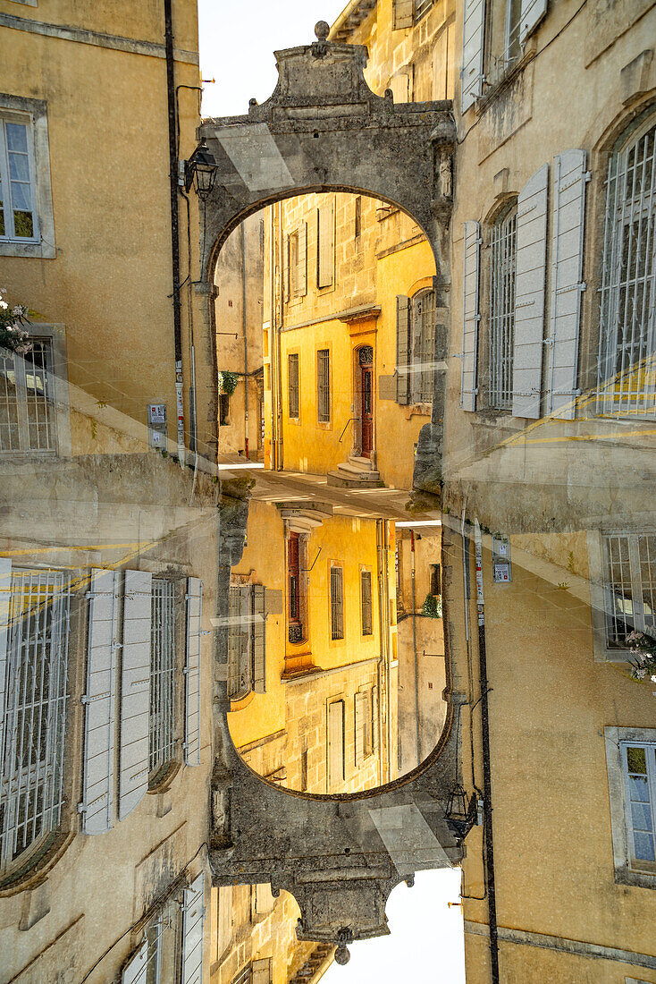 Graphic double exposure of a arched gate in the medieval town of Arles, France.