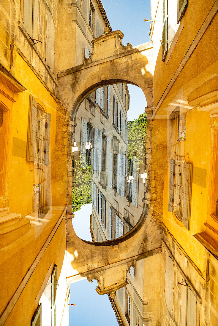 Grafische Doppelbelichtung eines gewölbten Tores in der mittelalterlichen Stadt Arles, Frankreich.