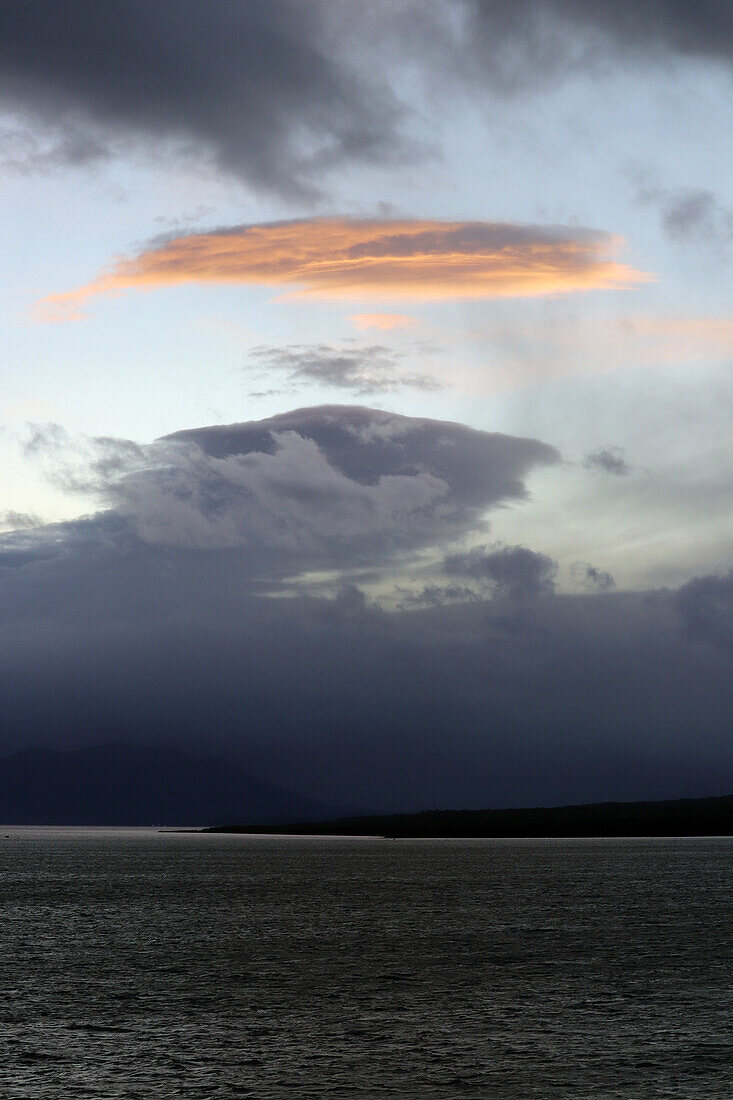 Chile; Südchile; Region Magallanes; Gebirge der südlichen Cordillera Patagonica; Seno Ultima Esperanza bei Puerto Natales; Regenwolken verdunkeln die Landschaft; Wolke von der Sonne angestrahlt;