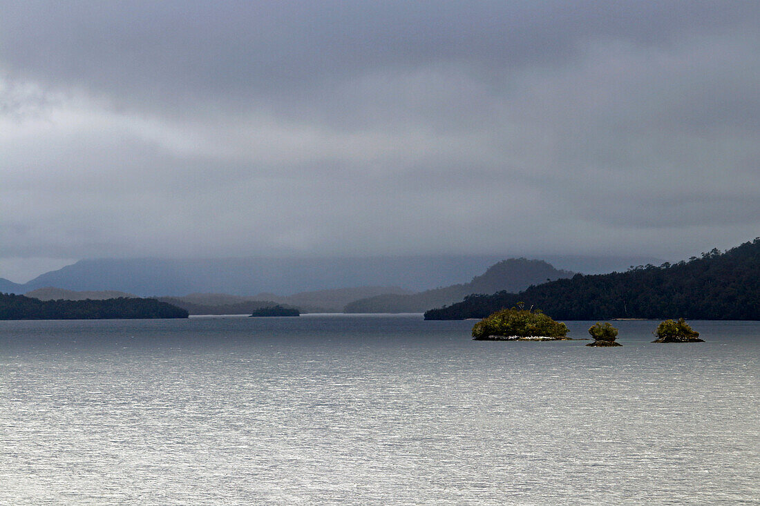 Chile; Südchile; Region Aysen; Gebirge der südlichen Cordillera Patagonica; auf der Navimag Fähre durch die patagonischen Fjorde; Inseln im Canal Polluche; tief hängende Regenwolken