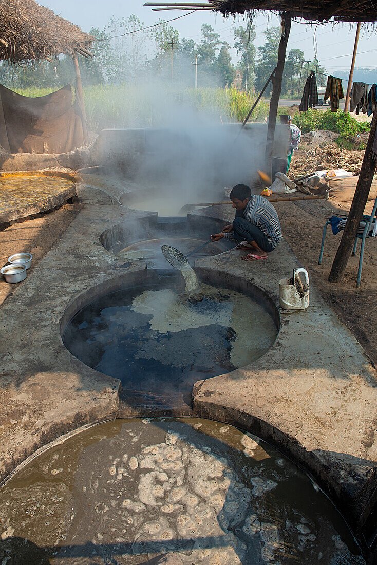 Gewinnung von Zucker durch Einkochen des ausgepressten  Zuckerrohrsafts, Bihar, Indien