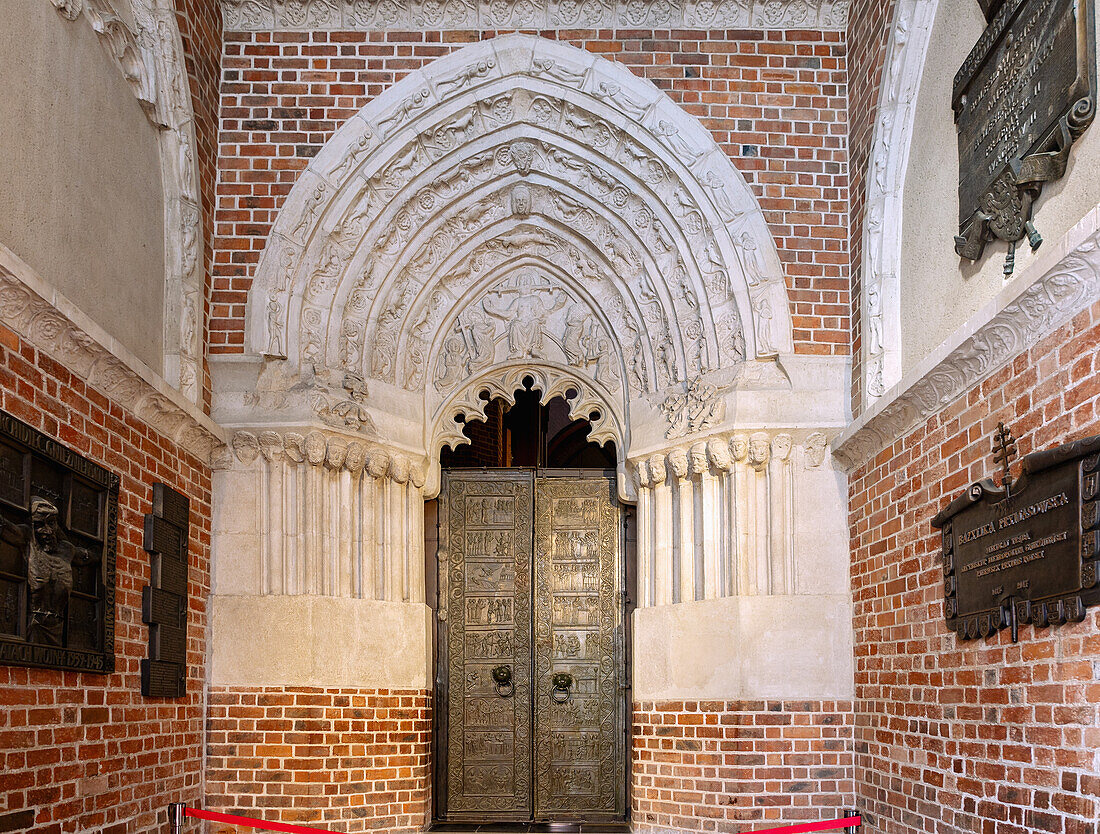 Gothic south portal and bronze door of the Cathedral of the Assumption of the Virgin Mary and St. Adalbert (Gniezno Cathedral; Archcathedral of Gniezno; Primate's Basilica of the Assumption of Our Lady; Bazylika archikatedralna Wniebowzięcia NMP) with Martyrdom of St. Adalbert in Gniezno (Gniezno) in the Wielkopolska Voivodeship of Poland