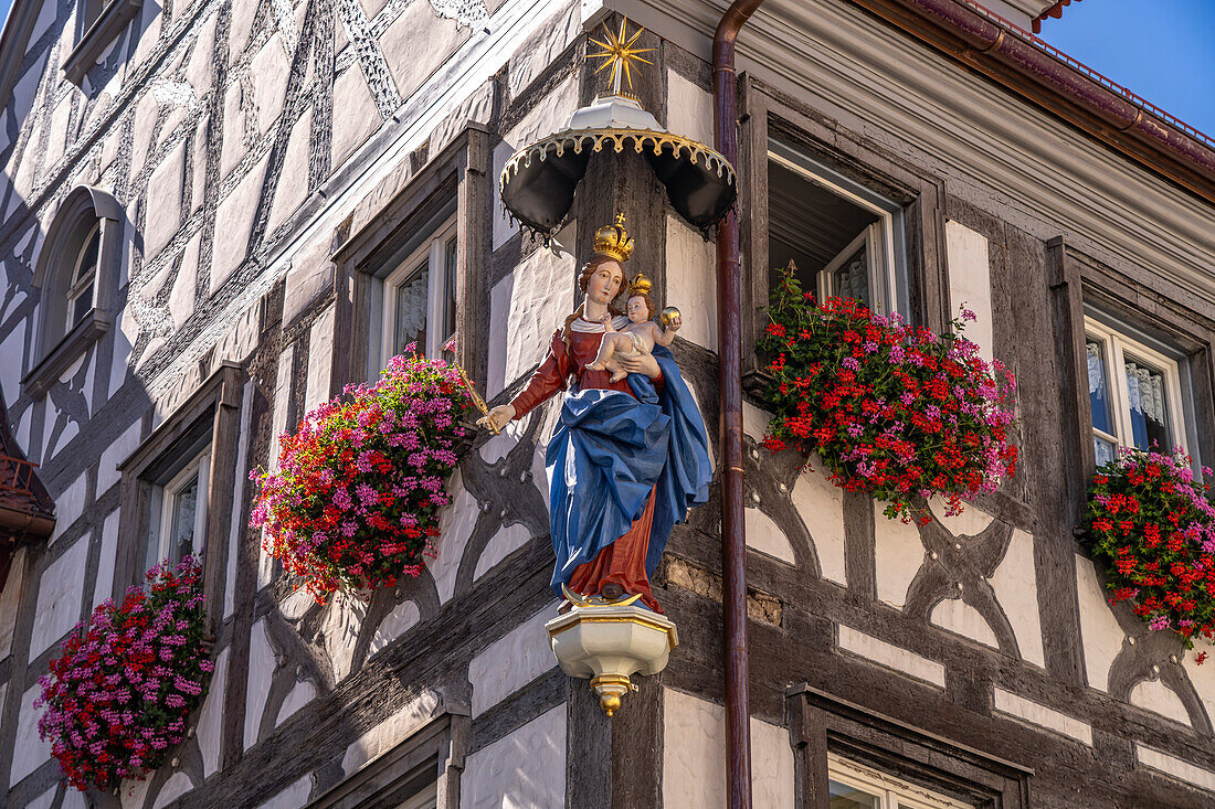 Madonna mit Kind und Blumenschmuck an einem Fachwerkhaus in Forchheim, Oberfranken, Bayern, Deutschland