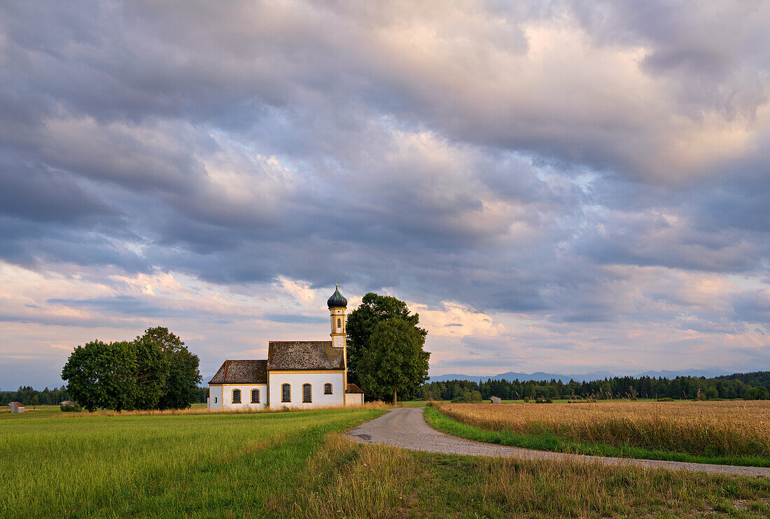Wolkenhimmel über St. Johannes dem Täufer an einem Sommerabend, Raisting, Weilheim, Bayern, Deutschland, Europa