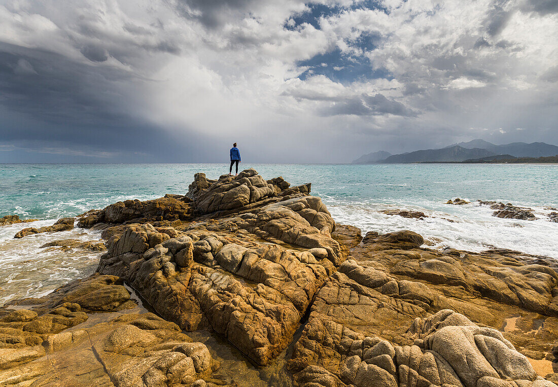 Junge Frau an der Küste beim Torre di Bari, Bari Sardo, Sardinien, Italien