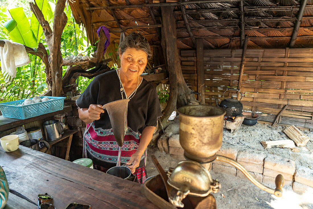 Karen woman making coffee in her kitchen in Mae Klang Luang village, Doi Inthanon National Park, Chiang Mai, Thailand, Asia