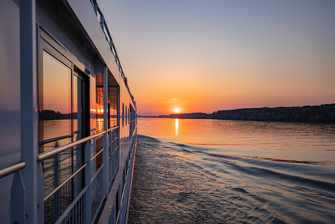 Window reflection on board river cruise ship Maxima (Nicko Cruises) on the Danube at sunset, near Golubac, Caraș-Severin, Romania, Europe