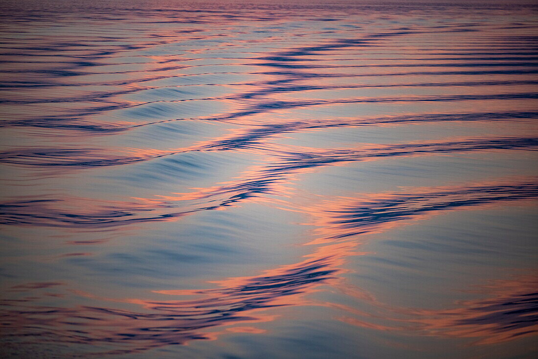 Reflection of clouds and sunset in wake of river cruise ship Maxima (Niko Cruises) on Danube River at dusk, near Coronini, Caraș-Severin, Romania, Europe