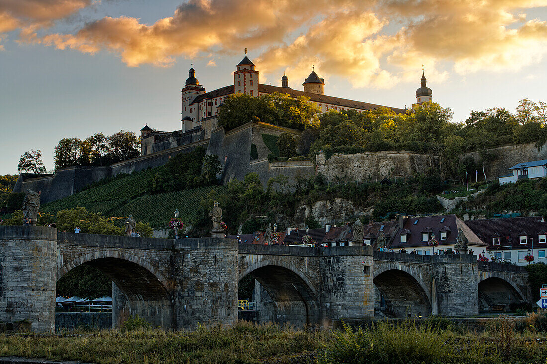 Blick von der Mainpromenade auf die Alte Mainbrücke und die Festung Marienberg in Würzburg zum Sonnenuntergang, Unterfranken, Franken, Bayern, Deutschland                             
