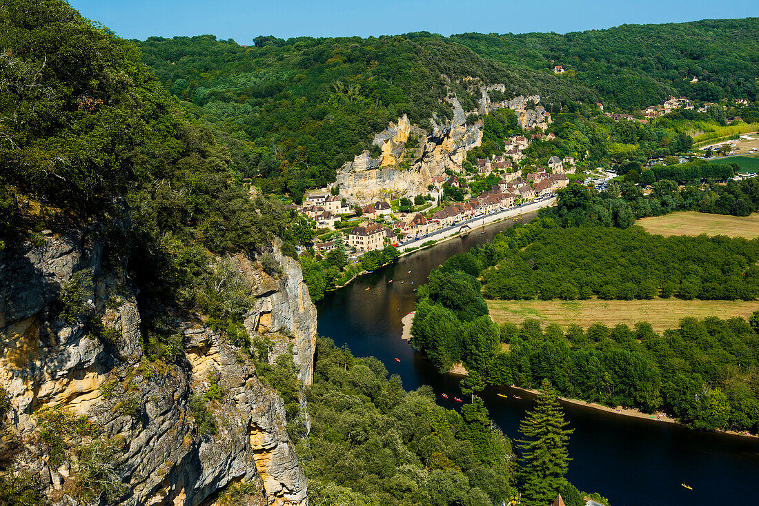 Blick auf Dorf mit Felsen am Fluss, bei La Roque-Gageac, Périgord, Departement Dordogne, Region Nouvelle-Aquitaine, Frankreich