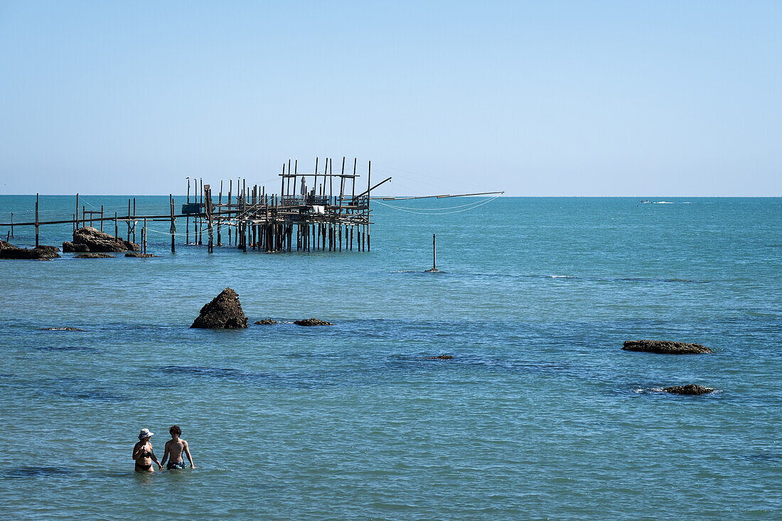 View of a Trabocco pile dwelling with couple in the foreground, Vasto, Abruzzo, Chieti Province, Italy, Europe
