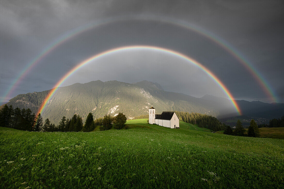 Ein doppelter Regenbogen über der Kirche Son Roc, Del, Salouf, Schweiz