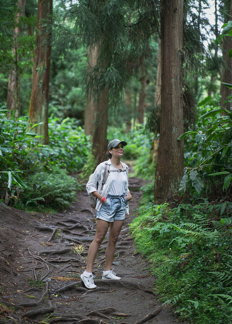  Woman hiking through the forests of the Azores island of Sao Miguel. 