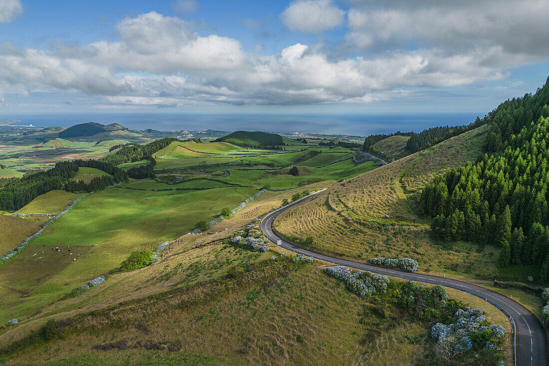 Blick aus der Vogelperspektive auf eine Straße in die Berge vom Miradouro do Pico do Carvão auf der Insel Sao Miguel, Azoren