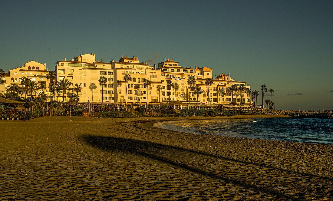  Beach and beach bay with the Park Paza apartments and beach restaurants in the evening light, Puerto Banús, Marbella, Costa del Sol, Andalusia, Spain 