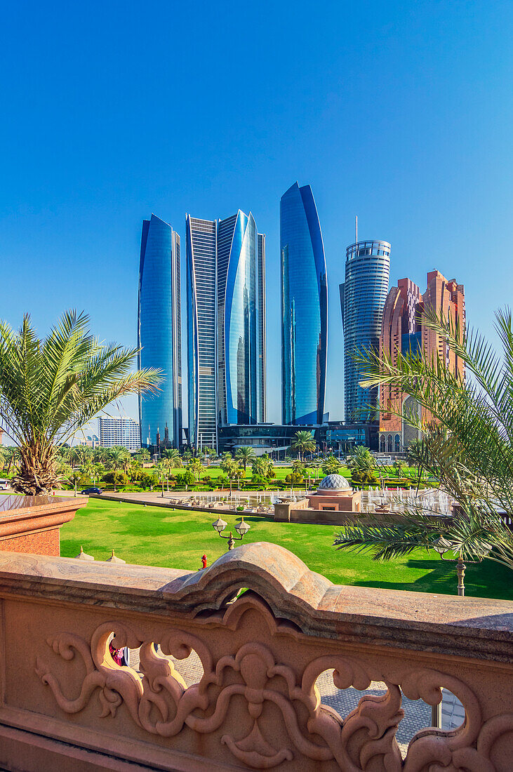Palmen und Wasserspiele in Grünanlage vor moderner Skyline, in Abu Dhabi, Vereinigte Arabische Emirate, Arabische Halbinsel, Persischer Golf