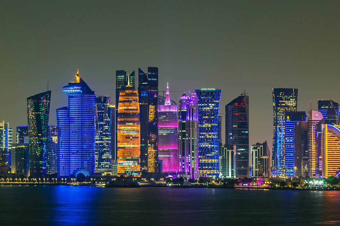 Hafenansichten mit bunt beleuchteter Skyline und Schiffen bei Nacht, Hauptstadt Doha, Emirat Katar, Persischer Golf