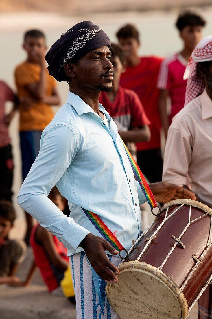  Local man plays drums to see off visitors at the pier, near Hadibu, Socotra Island, Yemen, Middle East 
