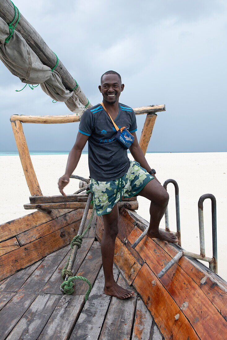 Einheimischer Mann auf einem traditionellen Dhau-Segelboot, in der Nähe von Stonetown, Sansibar-Stadt, Sansibar, Tansania, Afrika