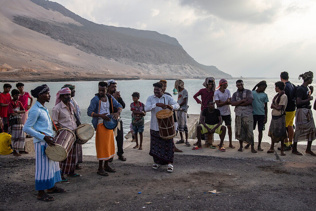  Villagers bid farewell to visitors at the pier with a traditional musical performance, near Hadibu, Socotra Island, Yemen, Middle East 