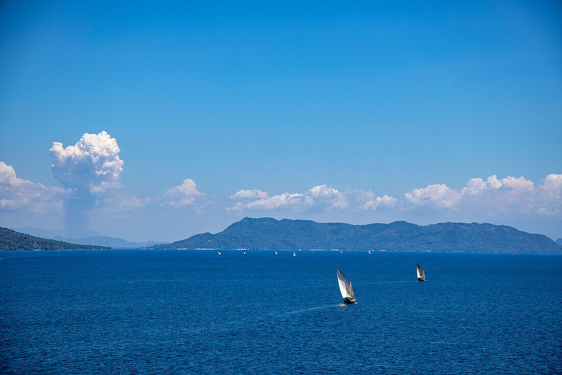Traditionelle Dhau-Segelboote mit Inseln in der Ferne, in der Nähe von Nosy Be, Diana, Madagaskar, Indischer Ozean