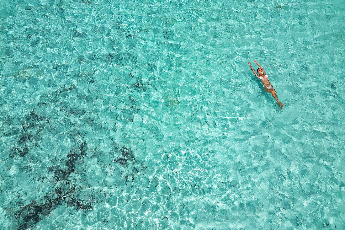  Aerial view of a woman swimming in shallow water, Assumption Island, Outer Islands, Seychelles, Indian Ocean 