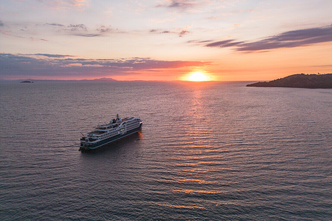 Luftaufnahme des Expeditionskreuzfahrtschiffes SH Diana (Swan Hellenic) bei Sonnenuntergang, in der Nähe von Nosy Be, Diana, Madagaskar, Indischer Ozean