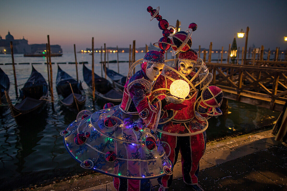 Karneval in Venedig: Prachtvolle Harlekinsmasken vor dem Canal Grande in der Nacht, Venedig, Italien