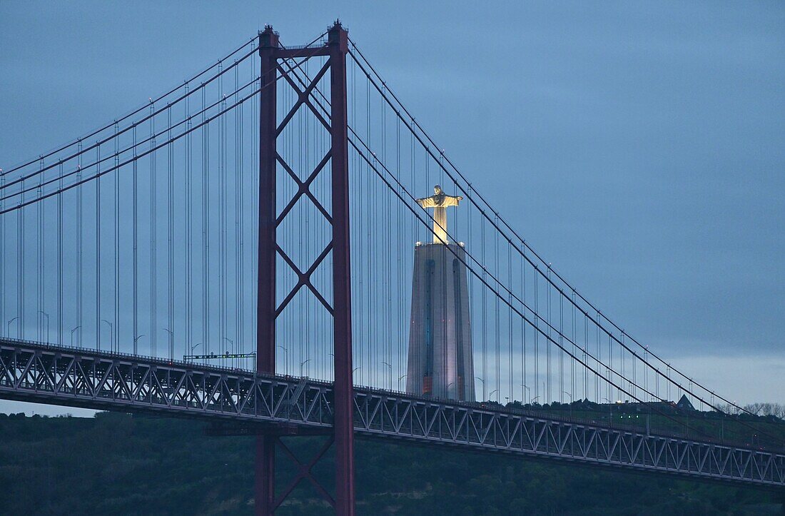 Cristo Rei Statue und Brücke Ponte de 25 Abril in der Abenddämmerung, Lissabon, Portugal