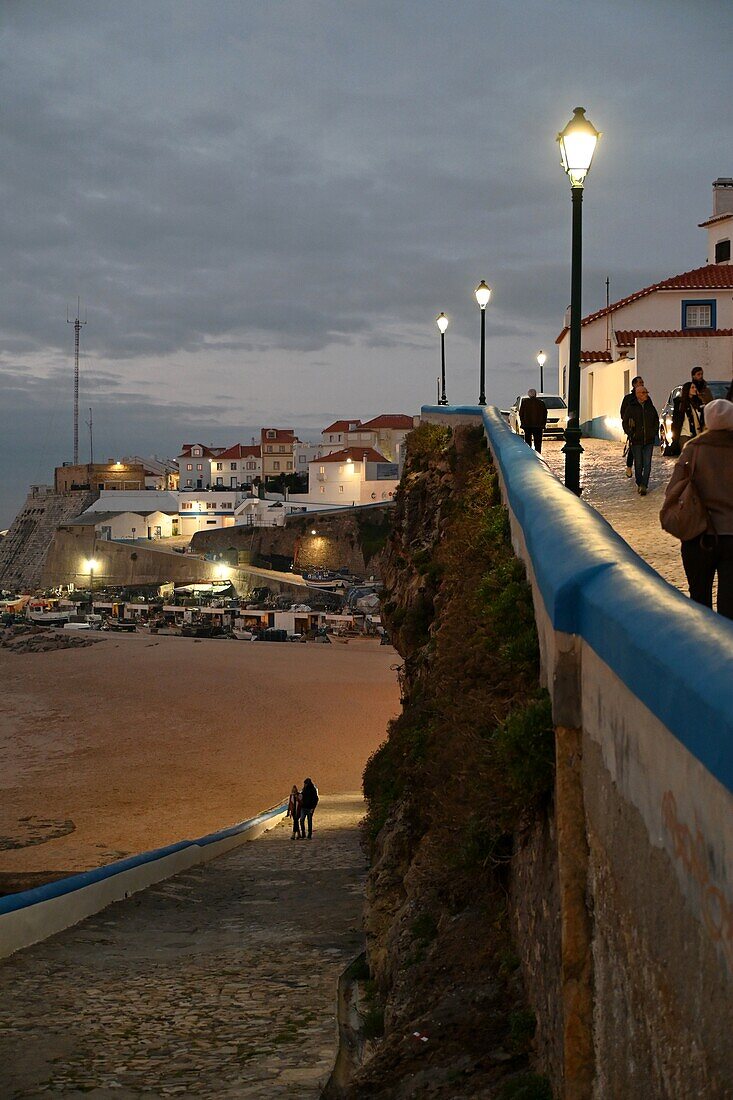 Spaziergänger an der Uferpromenade im Sonnenuntergang in Ericeira, Atlantikküste, Region Lissabon, Portugal