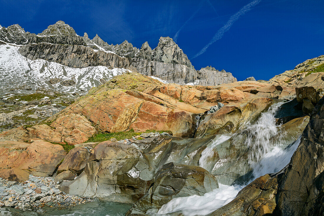 Wasserfall fließt über rote Felsplatten, Tschingelhörner im Hintergrund, Plaun Segnas Sut, Unterer Segnesboden, Tektonikarena Sardona, Glarner Hauptüberschiebung, UNESCO Weltnaturerbe Glarner Alpen, Glarner Alpen, Graubünden, Schweiz 