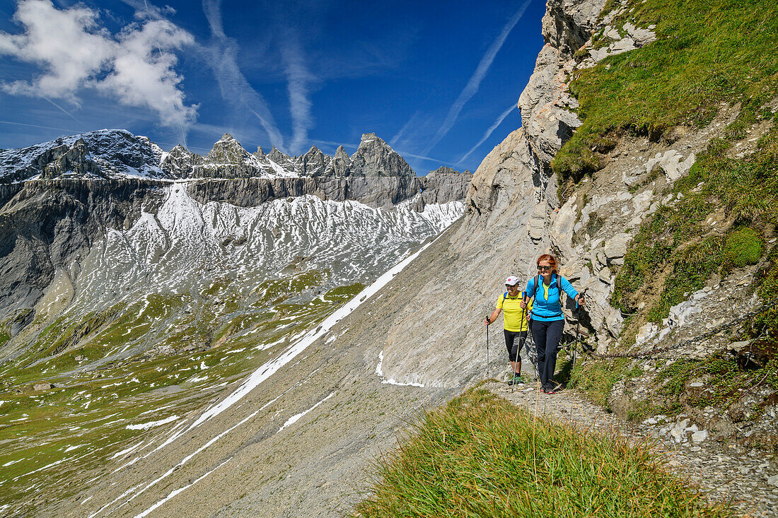  Man and woman hiking with a view of Tschingelhörner, Plaun Segnas Sut, Unterer Segnesboden, Tectonic Arena Sardona, Glarus thrust, UNESCO World Natural Heritage Glarus Alps, Glarus Alps, Graubünden, Switzerland  