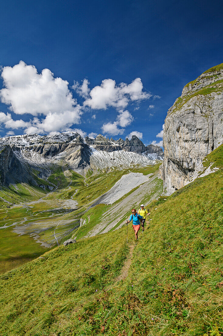  Man and woman hiking with a view of Tschingelhörner and Lower Segnesboden, Tectonic Arena Sardona, Glarus Main Thrust, UNESCO World Natural Heritage Glarus Alps, Glarus Alps, Graubünden, Switzerland  