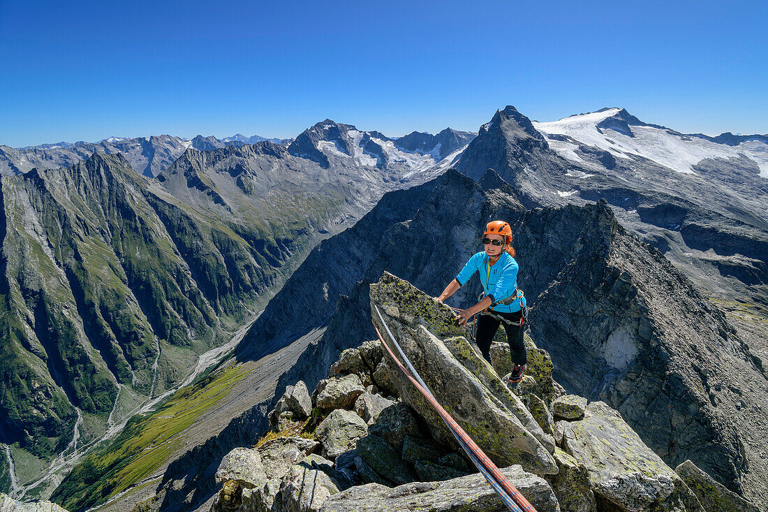  Woman climbing over boulders on Zsigmondyspitze, Zsigmondyspitze, Zillertal Alps, Zillertal Alps Nature Park, Tyrol, Austria 
