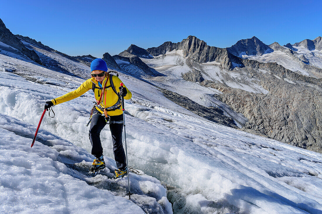 Frau beim Bergsteigen steigt über Gletscherspalte, Schwarzensteinkees, Schwarzenstein, Zillertaler Alpen, Naturpark Zillertaler Alpen, Tirol, Österreich