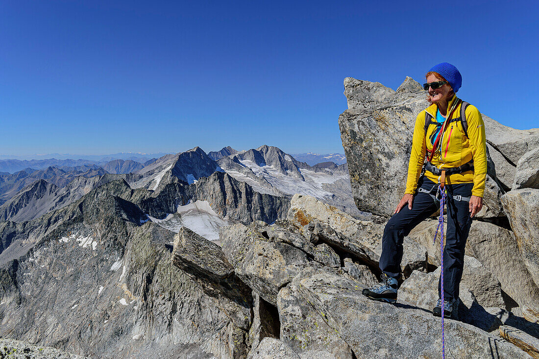 Frau beim Bergsteigen steht auf Felsgrat, Schwarzenstein, Zillertaler Alpen, Naturpark Zillertaler Alpen, Tirol, Österreich