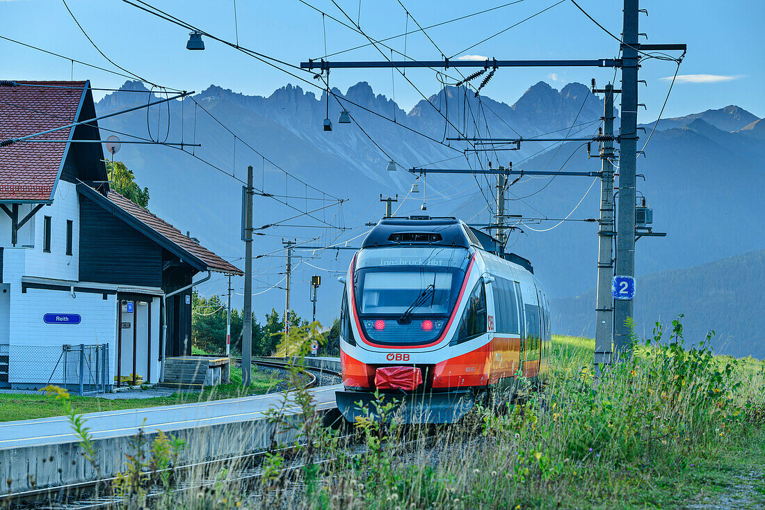 Bahn fährt in Bahnhof von Reith, mit Blick auf Kalkkögel, bei Reith, Karwendelbahn, Mittenwaldbahn, Tirol, Österreich