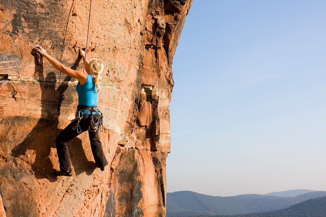  Young woman climbing the Rötzenstein pillar in the Palatinate, Gossersweiler-Stein, Rhineland-Palatinate, Germany 
