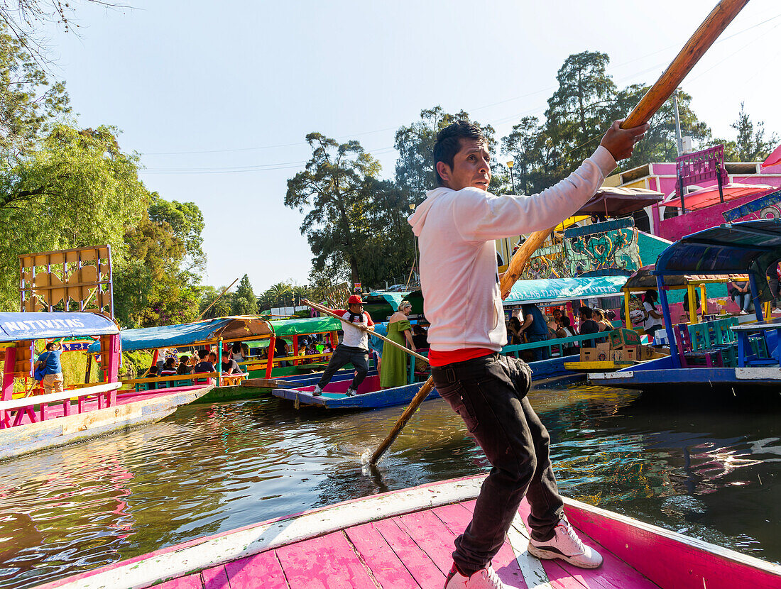 Beliebte Touristenattraktion: Menschen, die auf bunten Kähnen auf dem Kanal in Xochimiloco, Mexiko-Stadt, Mexiko Boot fahren - Stechkahn Trajinero