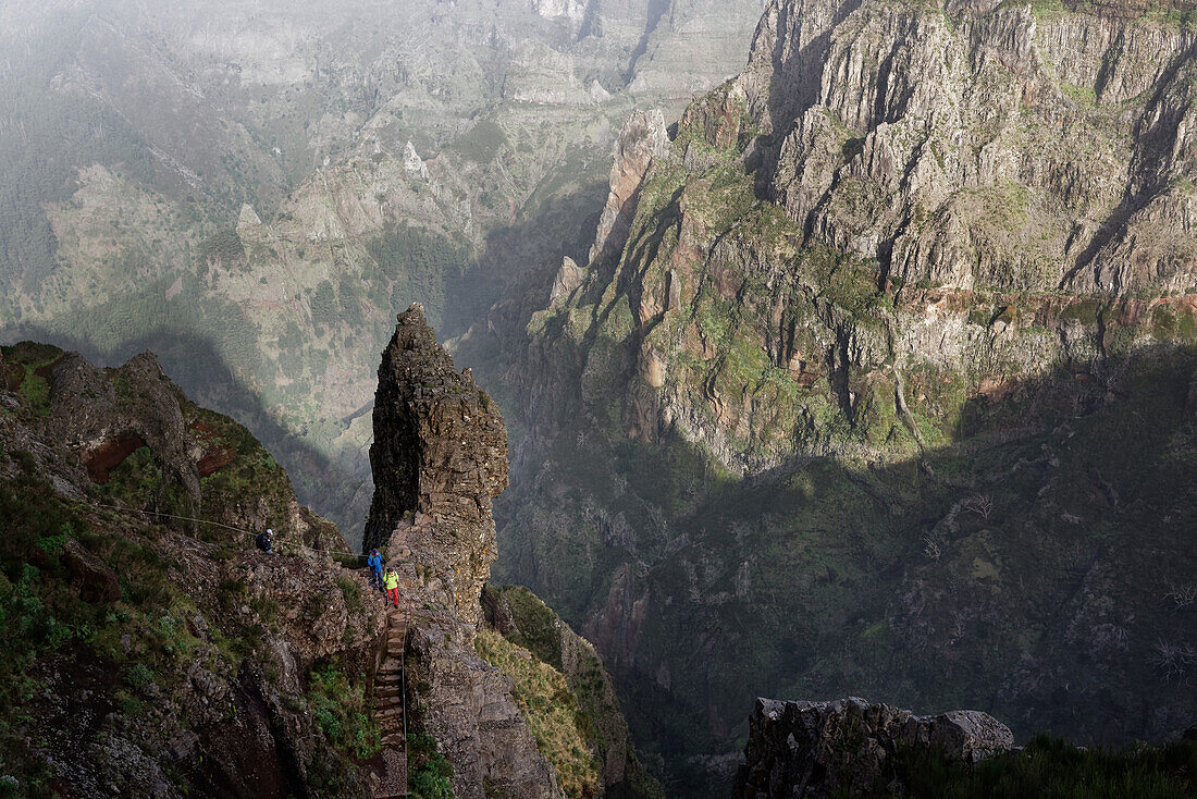 Wanderweg und Wanderer hoch über den Tälern am Pico do Arieiro, Madeira, Portugal.